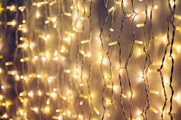 A curtain of warm white string lights, perfect for creating a cozy holiday ambiance during your holiday lights installation at 12900 Valley Branch Lane Suite 408 Farmers Branch, TX 75234.
