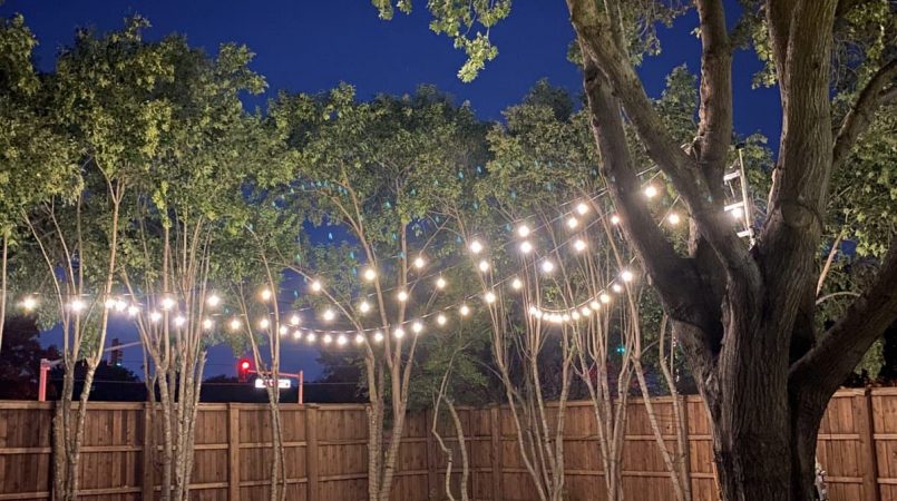Lighting overhead across an outdoor backyard pool. Patio Lighting Dallas, TX